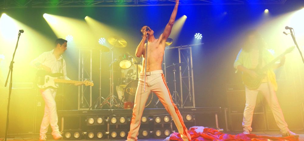 Queen tribute act, performing onstage amongst coloured lights